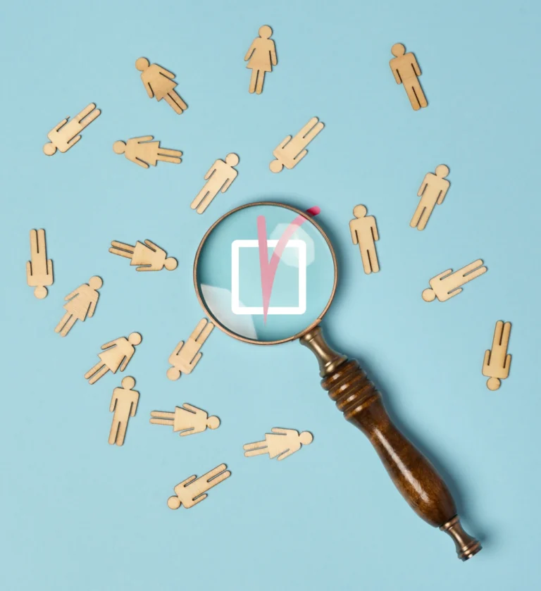 Magnifying glass focusing on people icons symbolizing recruitment and RPO fact-checking